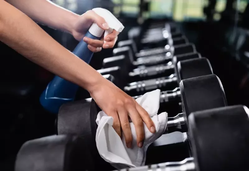 Wiping dumbbells clean.